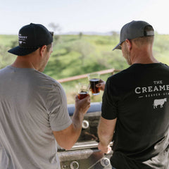 Two men outdoors wearing The Creamery Black Caddy Hat and The Creamery Dark Grey Driver Hat